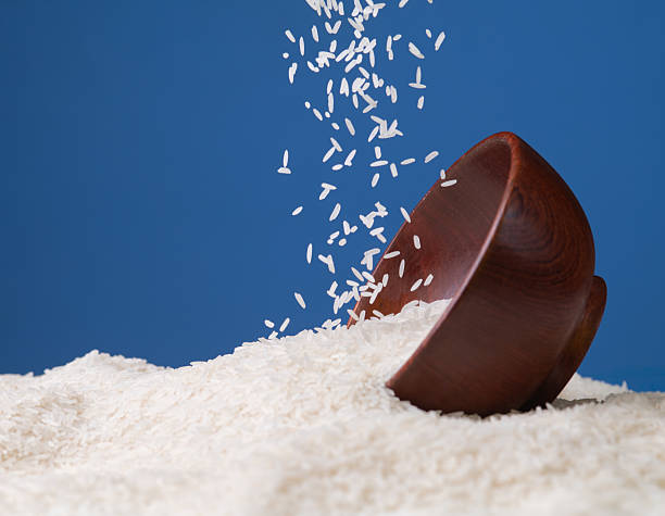 Pouring rice onto the bowl against a blue background